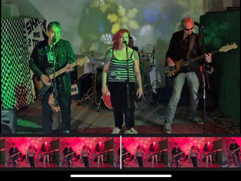 A band of a singer and 2 guitarists performing on stage.