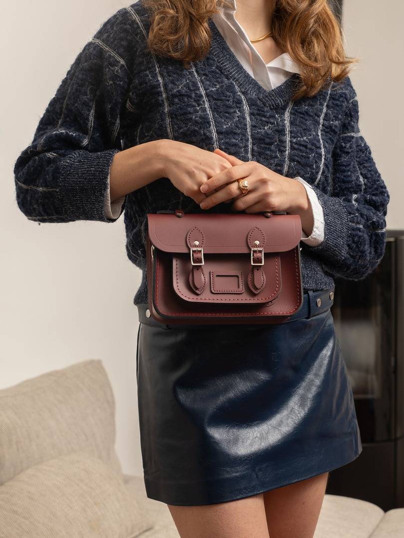 Model holding a Cambridge Satchel England bag