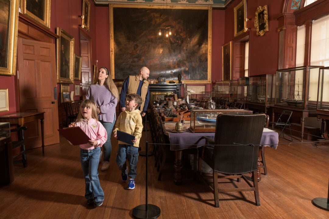 2 adults and 2 young children exploring a room filled with nautical objects.