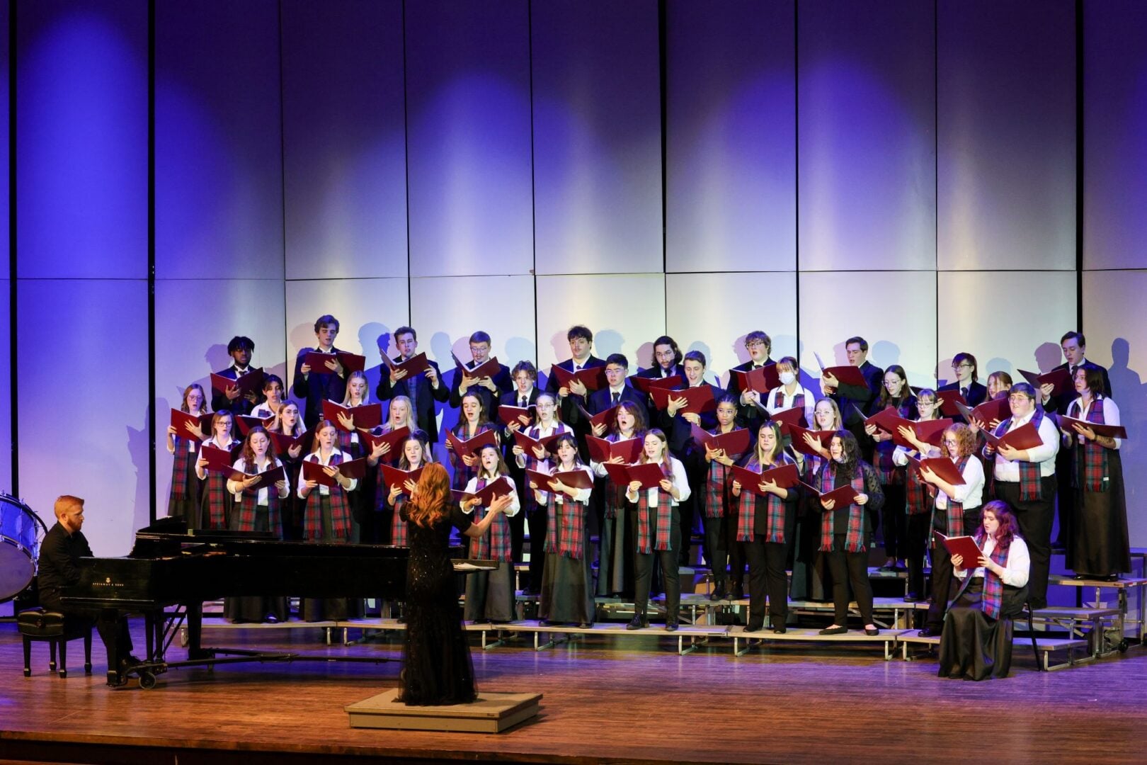 A group of people standing on a stage, singing.