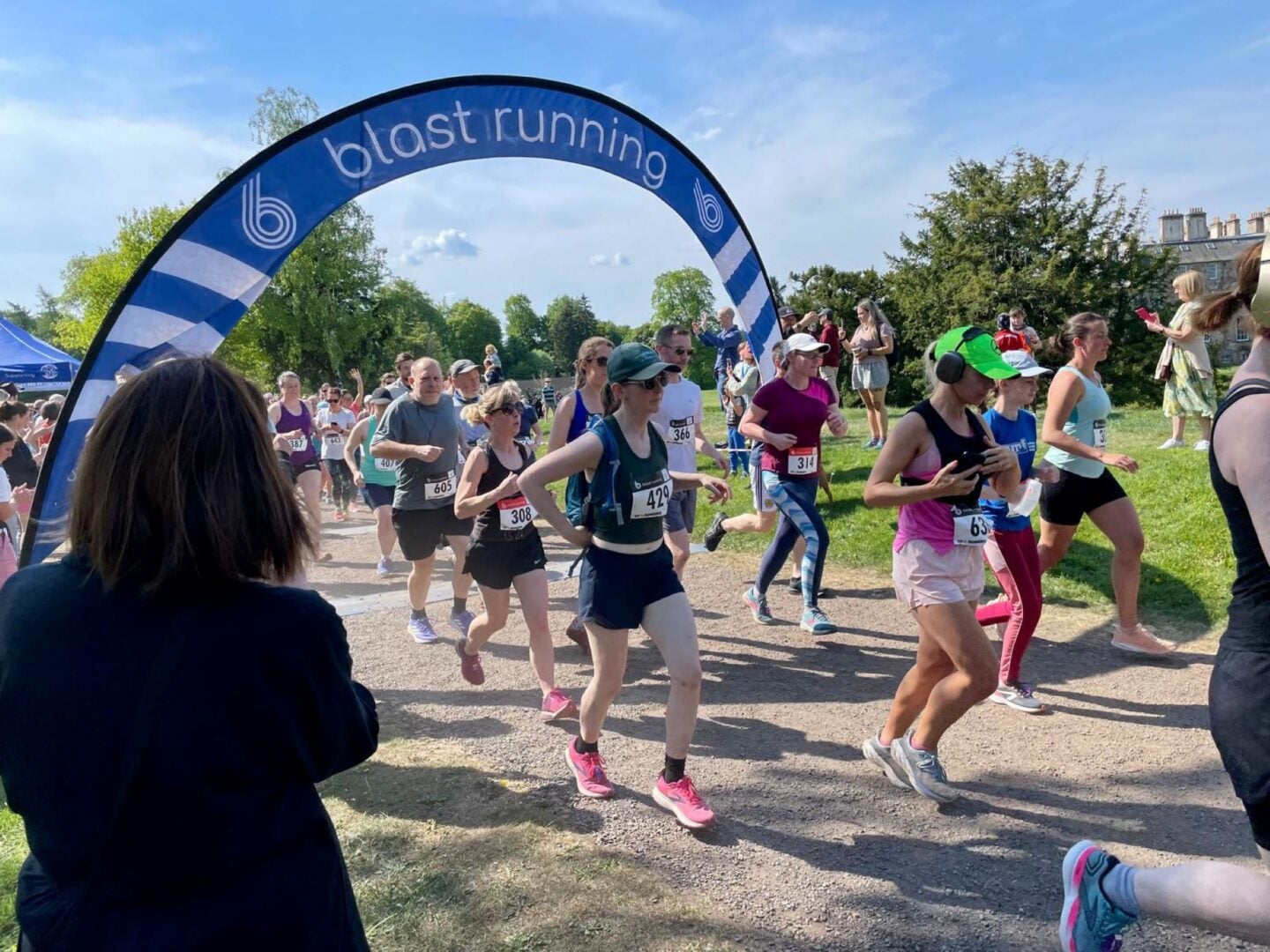 A group of people in sports gear running along a gravel path.