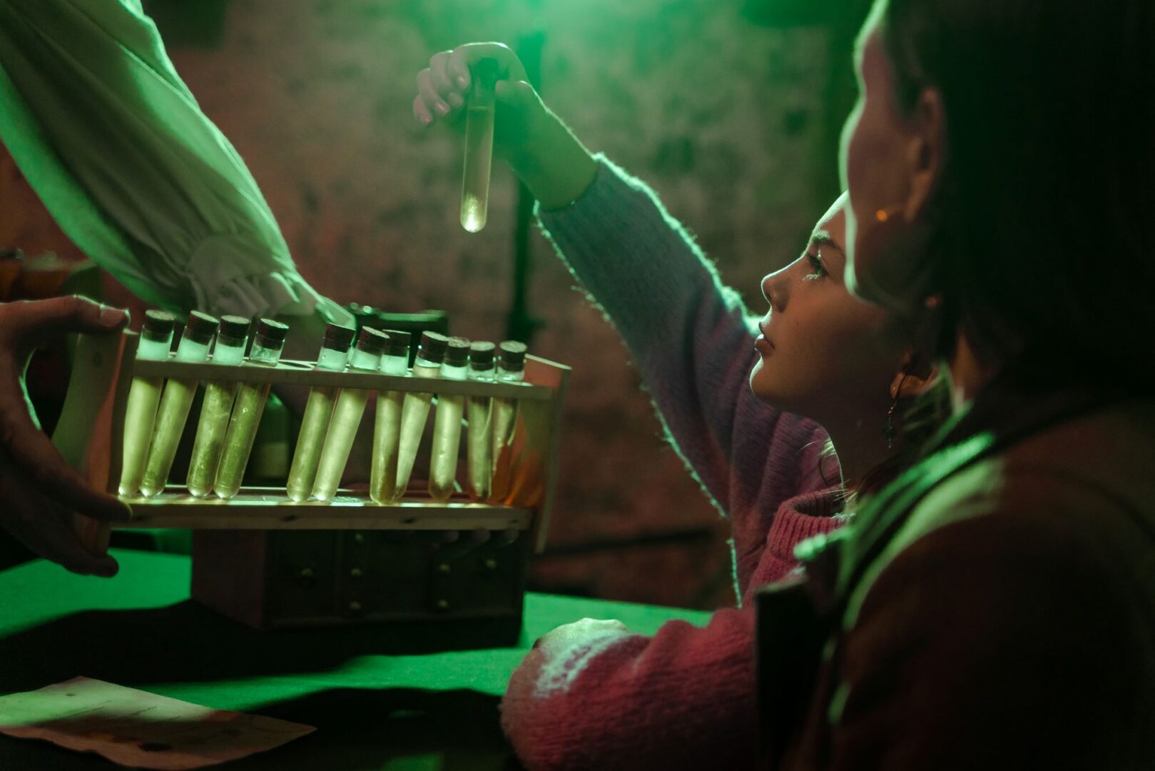 A young girl removing a test tube from a rack.
