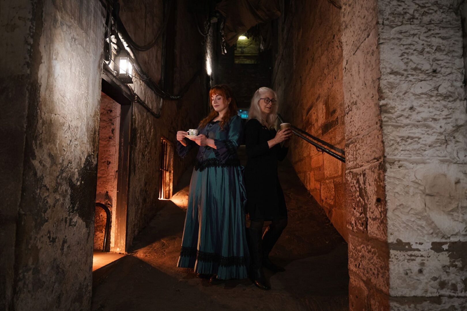 2 woman standing in an underground space.