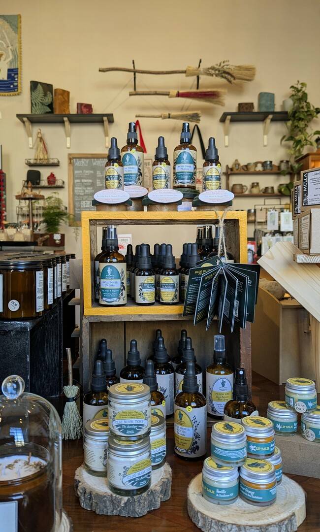 a sunny room with all-natural skincare products,, witches brooms, and candles