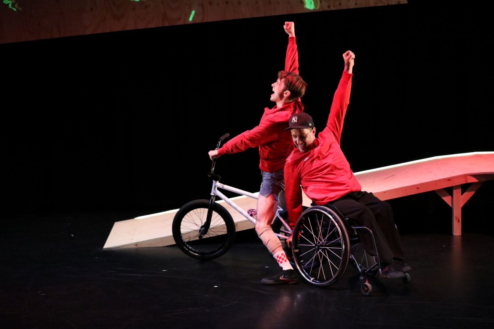 2 men, one on a bike, and one on a wheelchair.