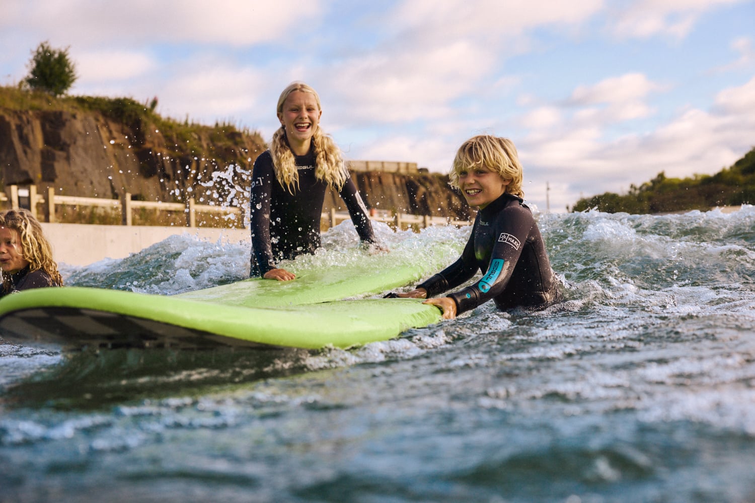 Family at Lost Shore Surf Resort about to climb on to Surf boards in the water