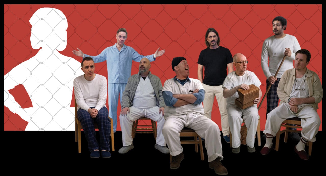 8 men, 5 seated, and 3 standing, in a row, against a red background.