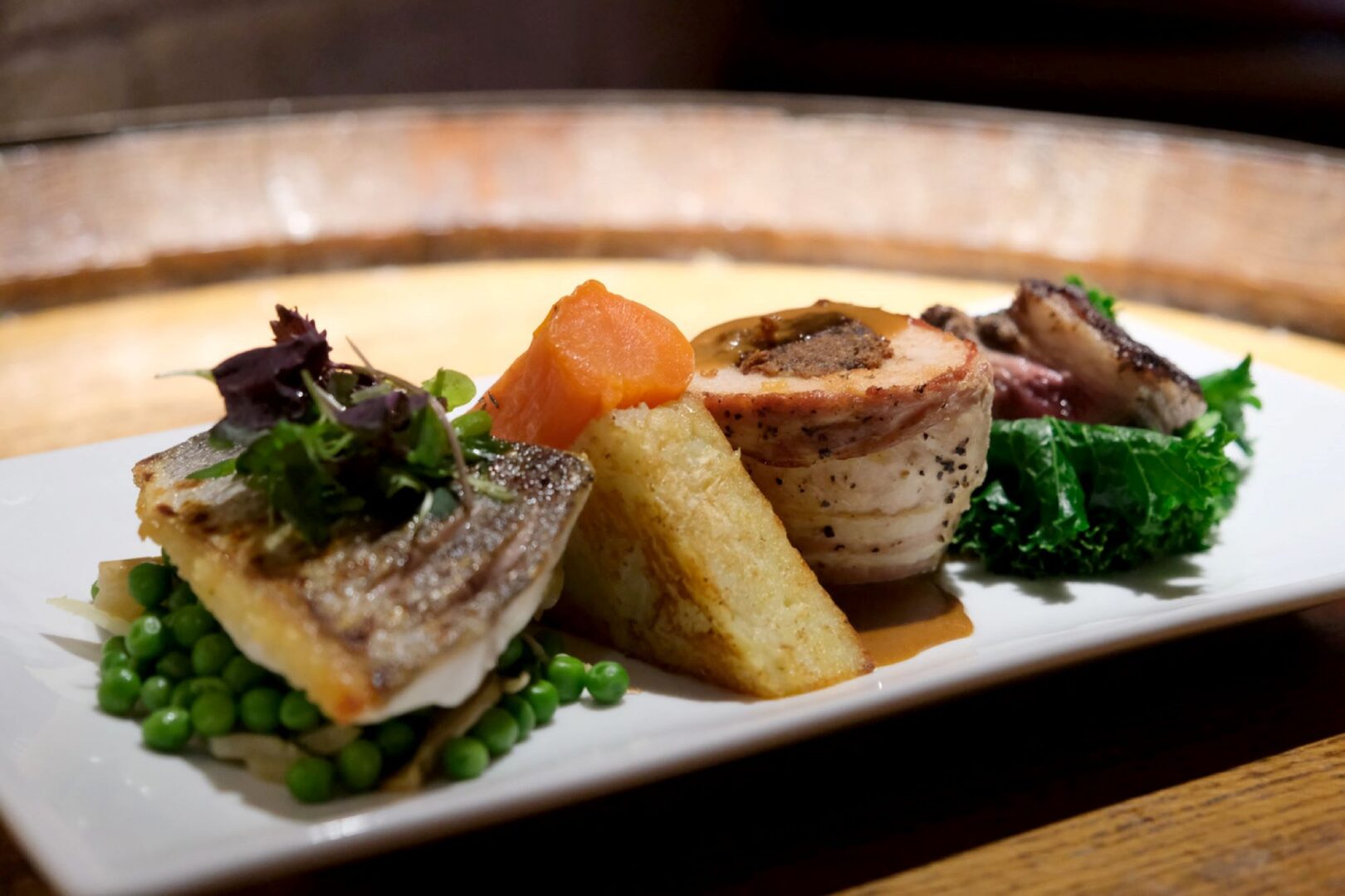 A plate of food, with fish, meat and vegetables.
