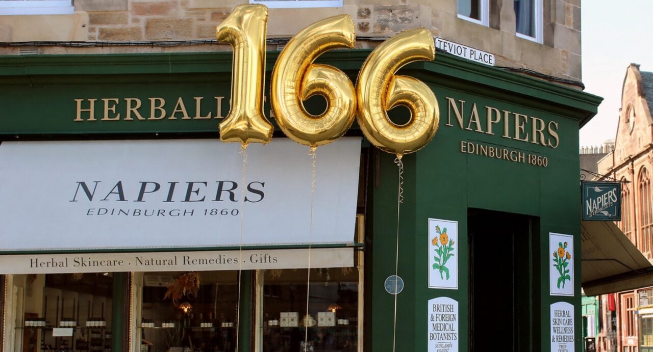 Exterior of shop building, with a large 166 gold balloon.