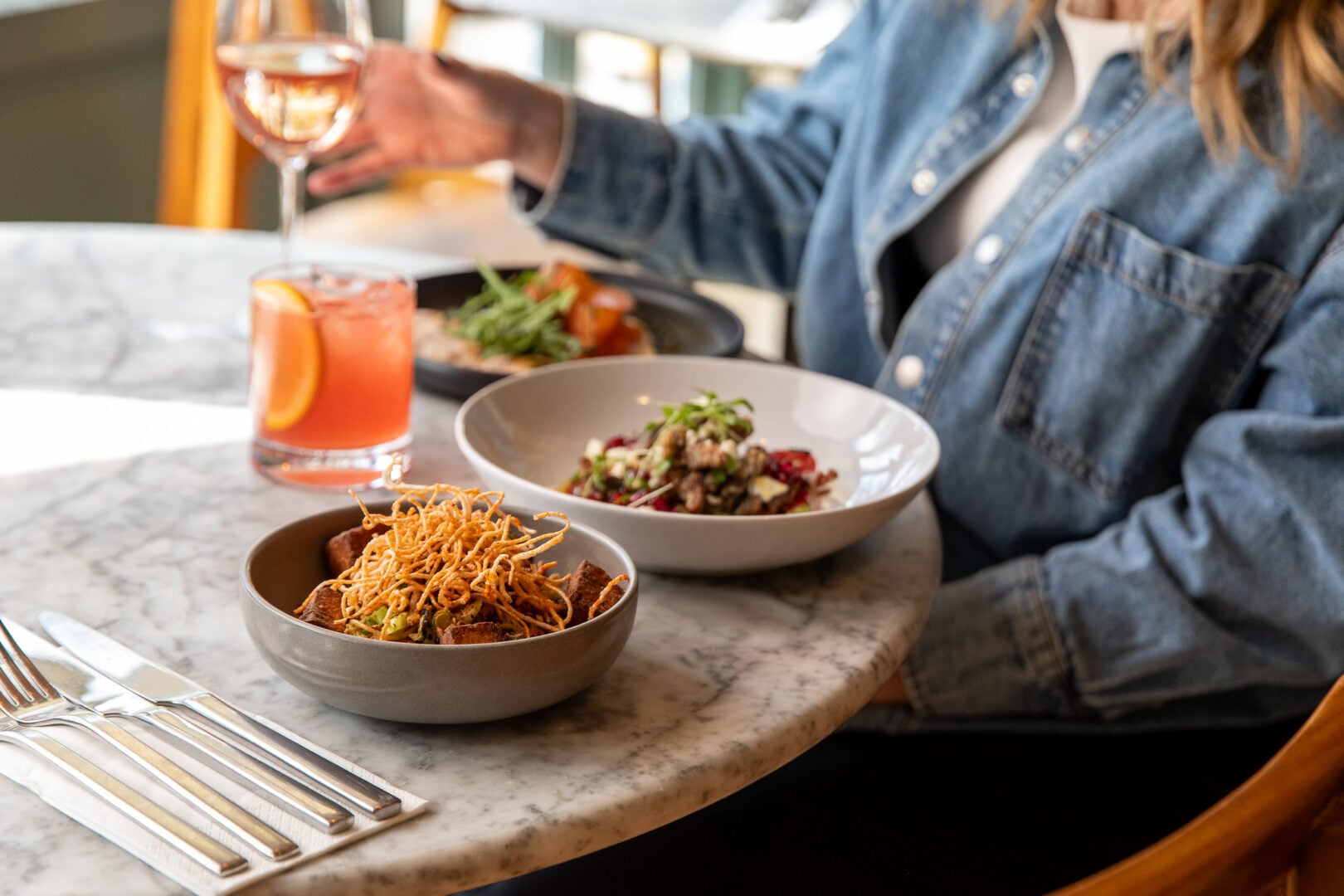 Lady eating items of food from the Herringbone spring menu