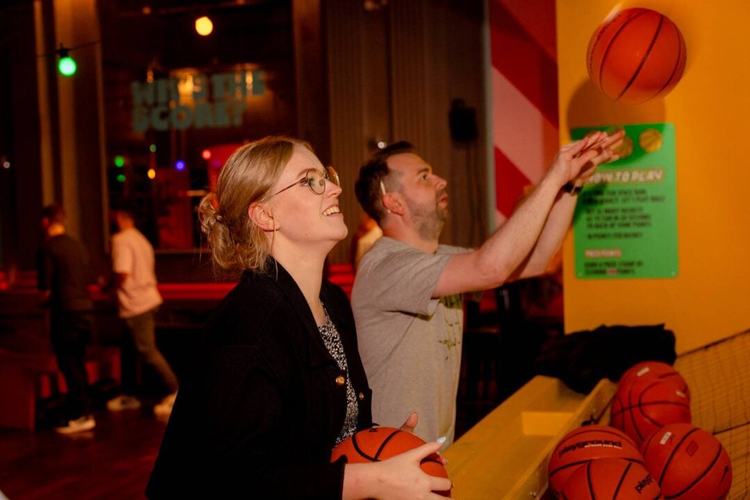 Man and woman enjoying a basketball shooting game