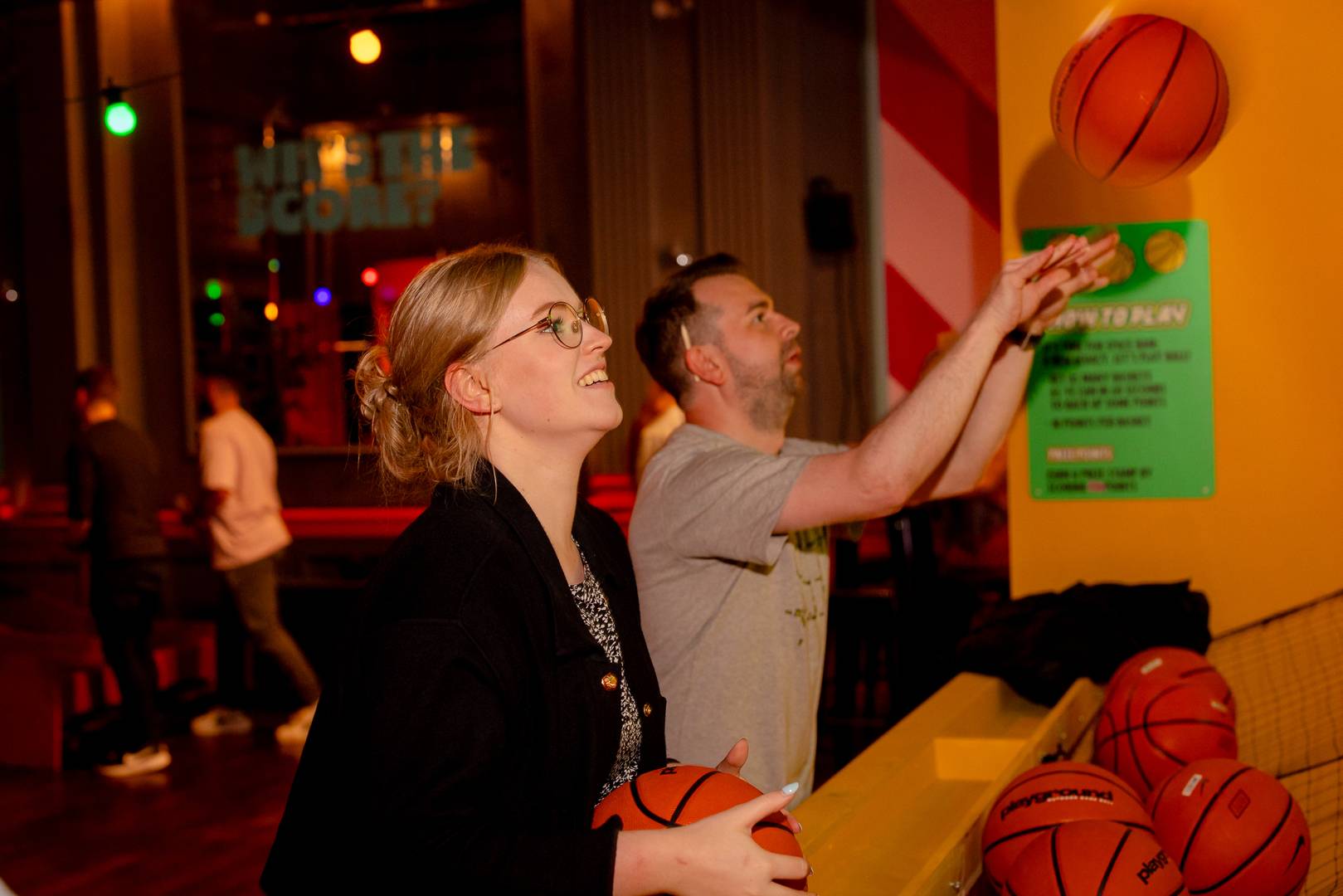 Man and woman enjoying a basketball shooting game