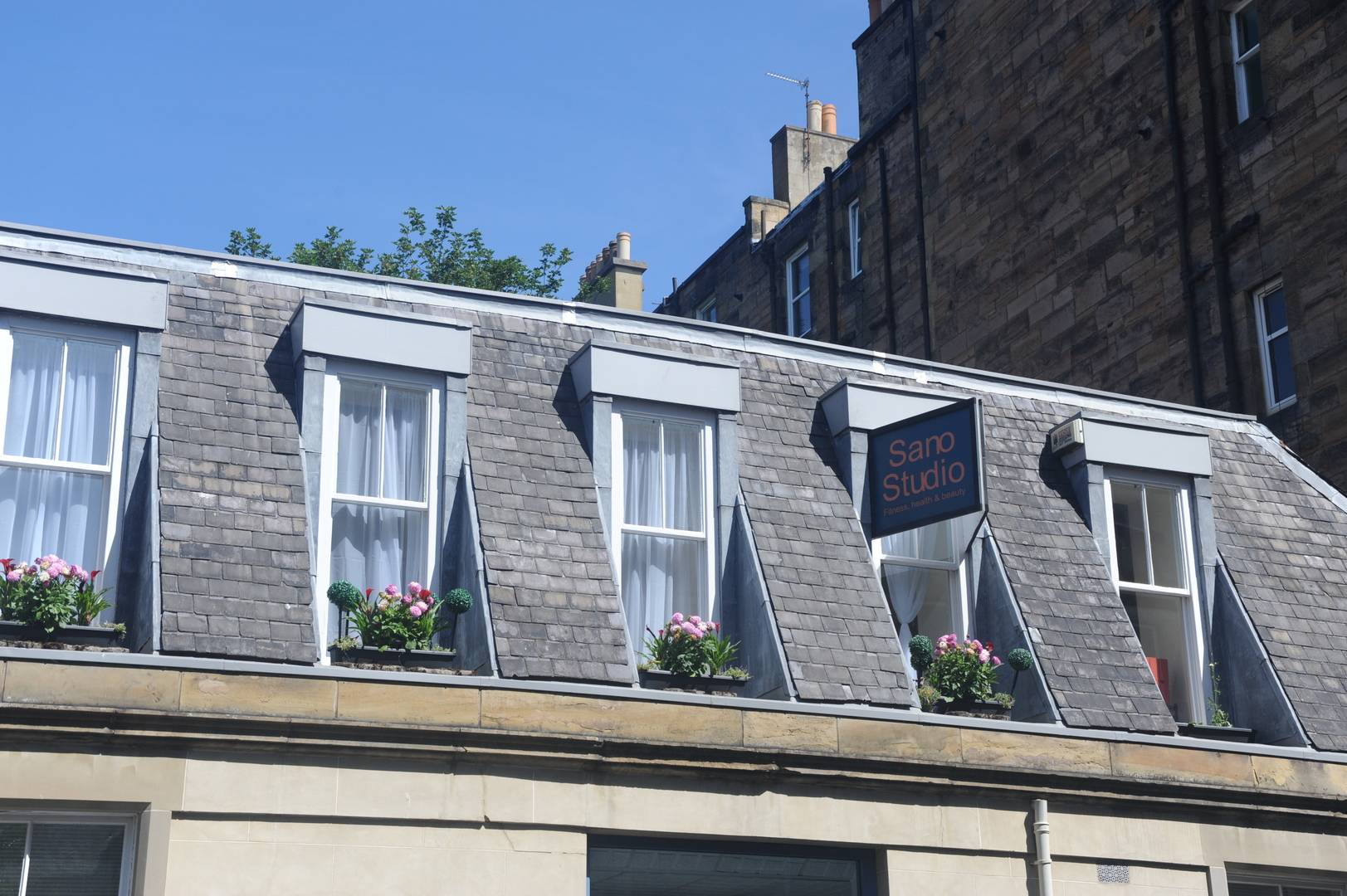 Exterior image of th first floor Pilates studio with large bay windows and flowers,© Owner Sano Studio Ltd