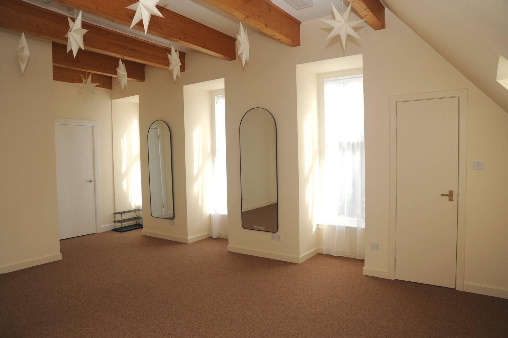 Mat Pilates studio with large bright windows and star ceiling decorations,© Owner Sano Studio Ltd