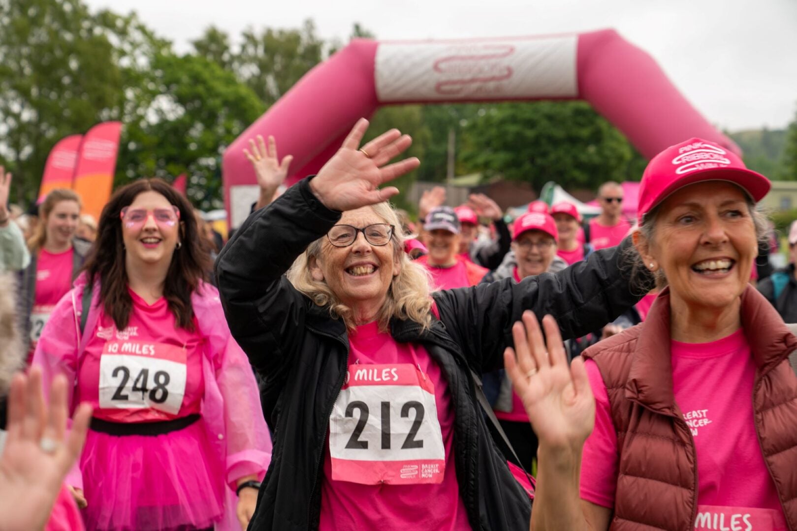 A group of people outdoors, all wearing pink.