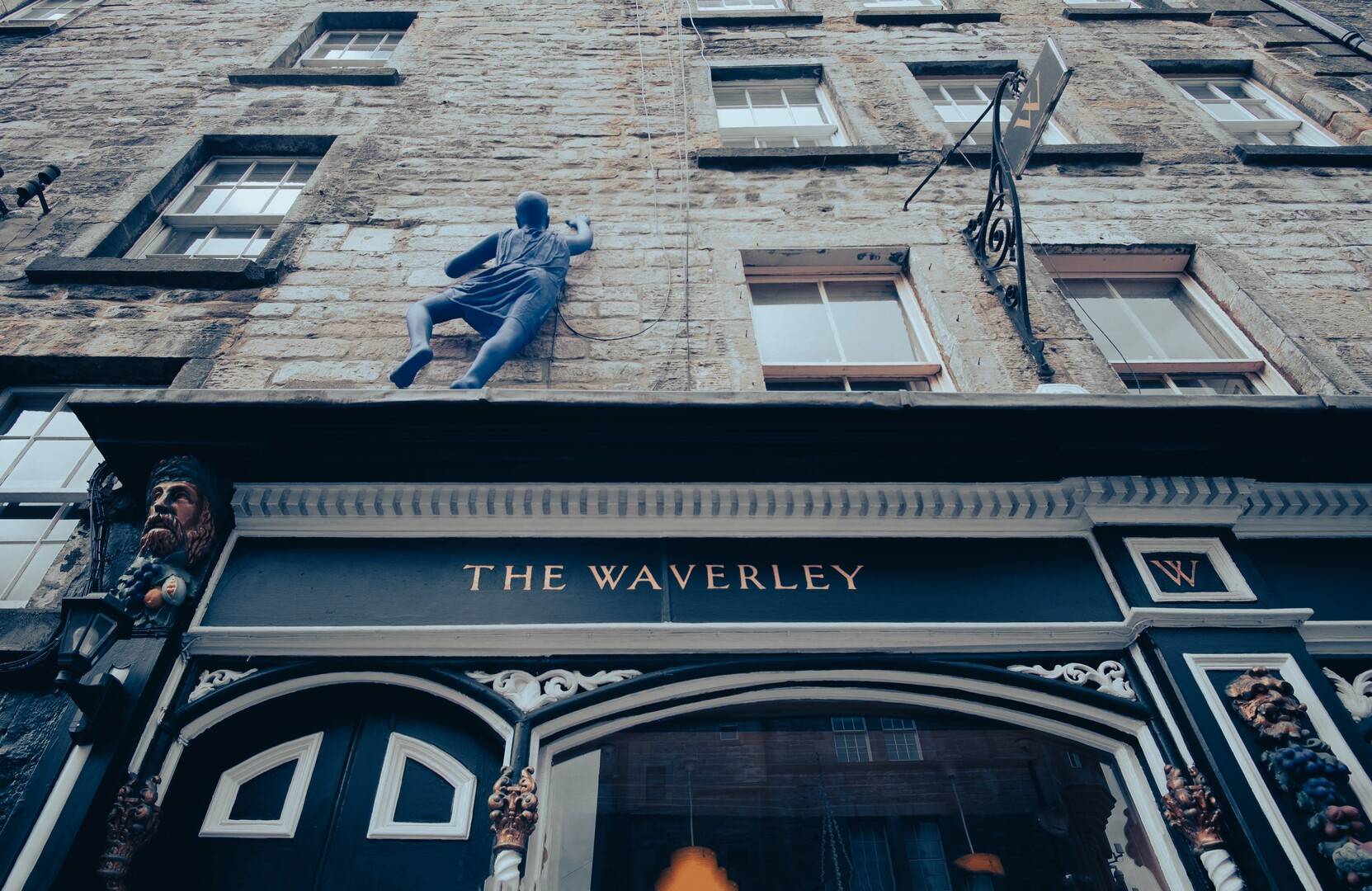 The Waverley sign with sculpture of person climbing up building above