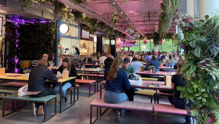People sitting at benches inside Edinburgh Street Food