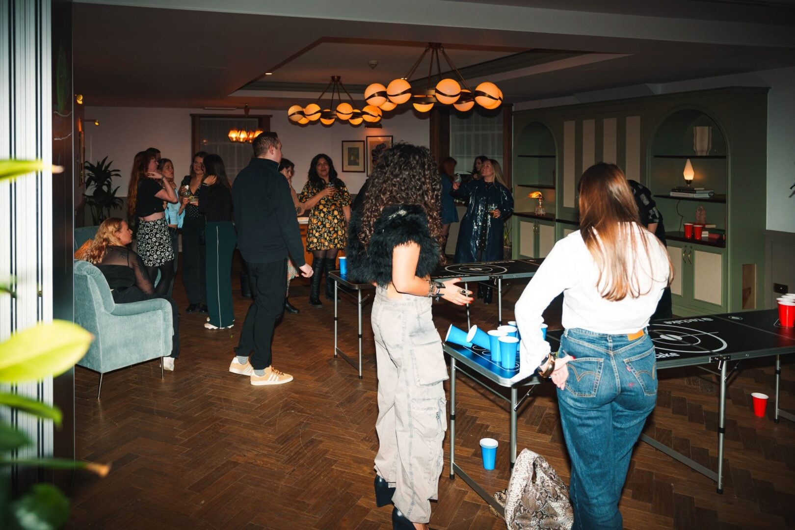 People gathered in a room, enjoying drinks.