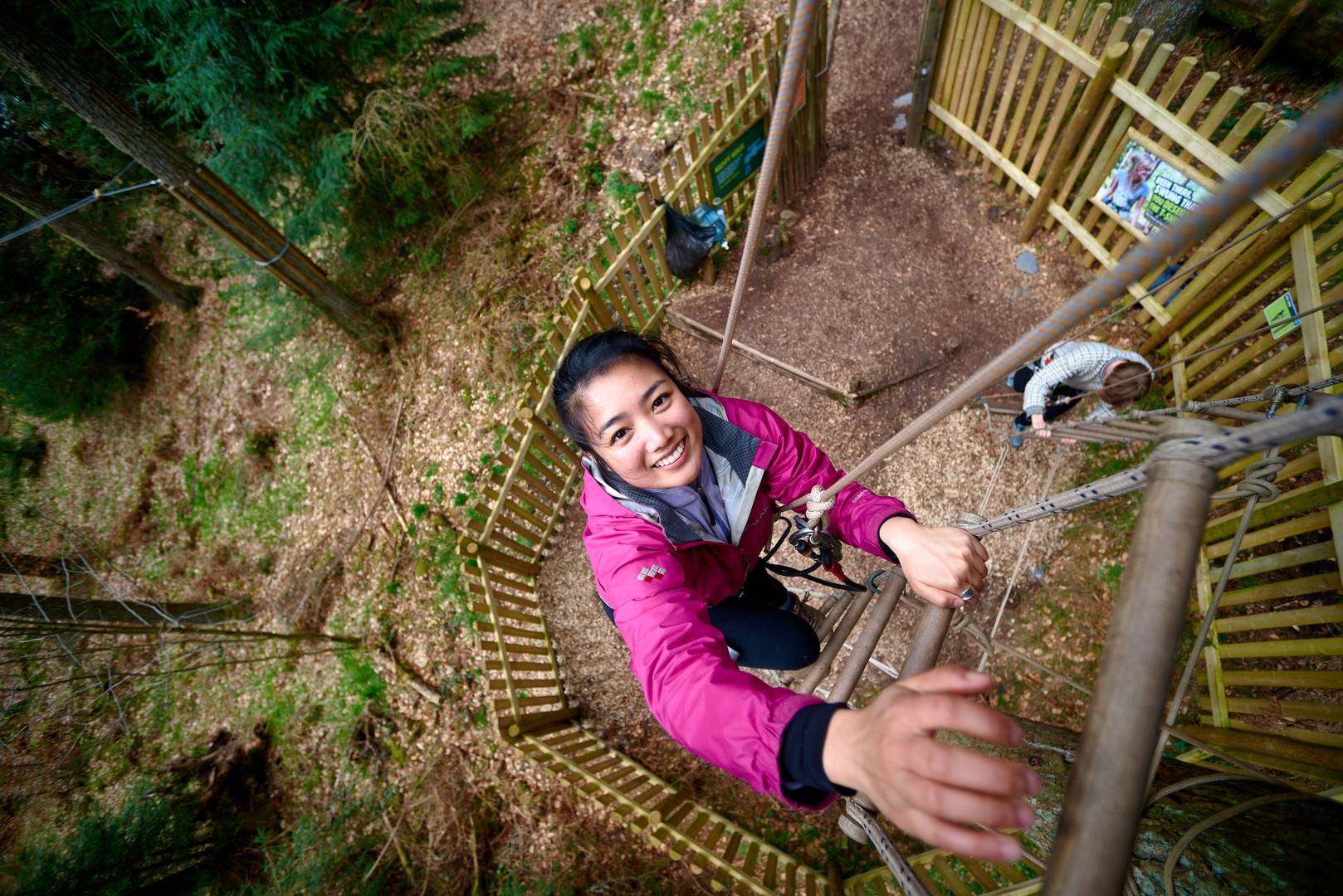 Girl climbing a rope ladder at Go Ape in Peebles