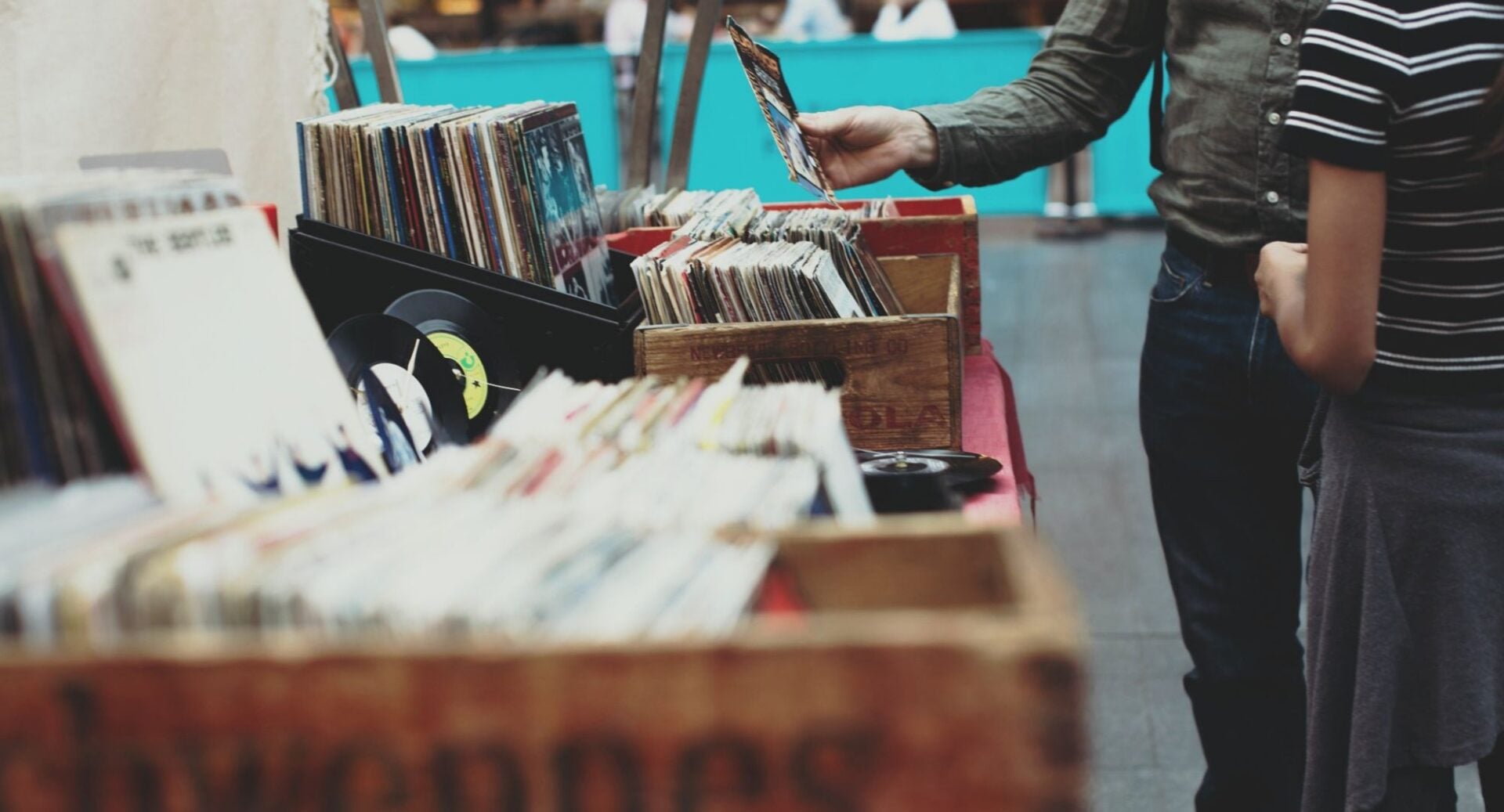 Close-up of people looking at a table set up with boxes of records.