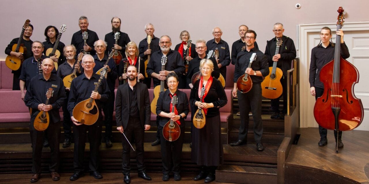 A group of people, holding a variety of instruments.