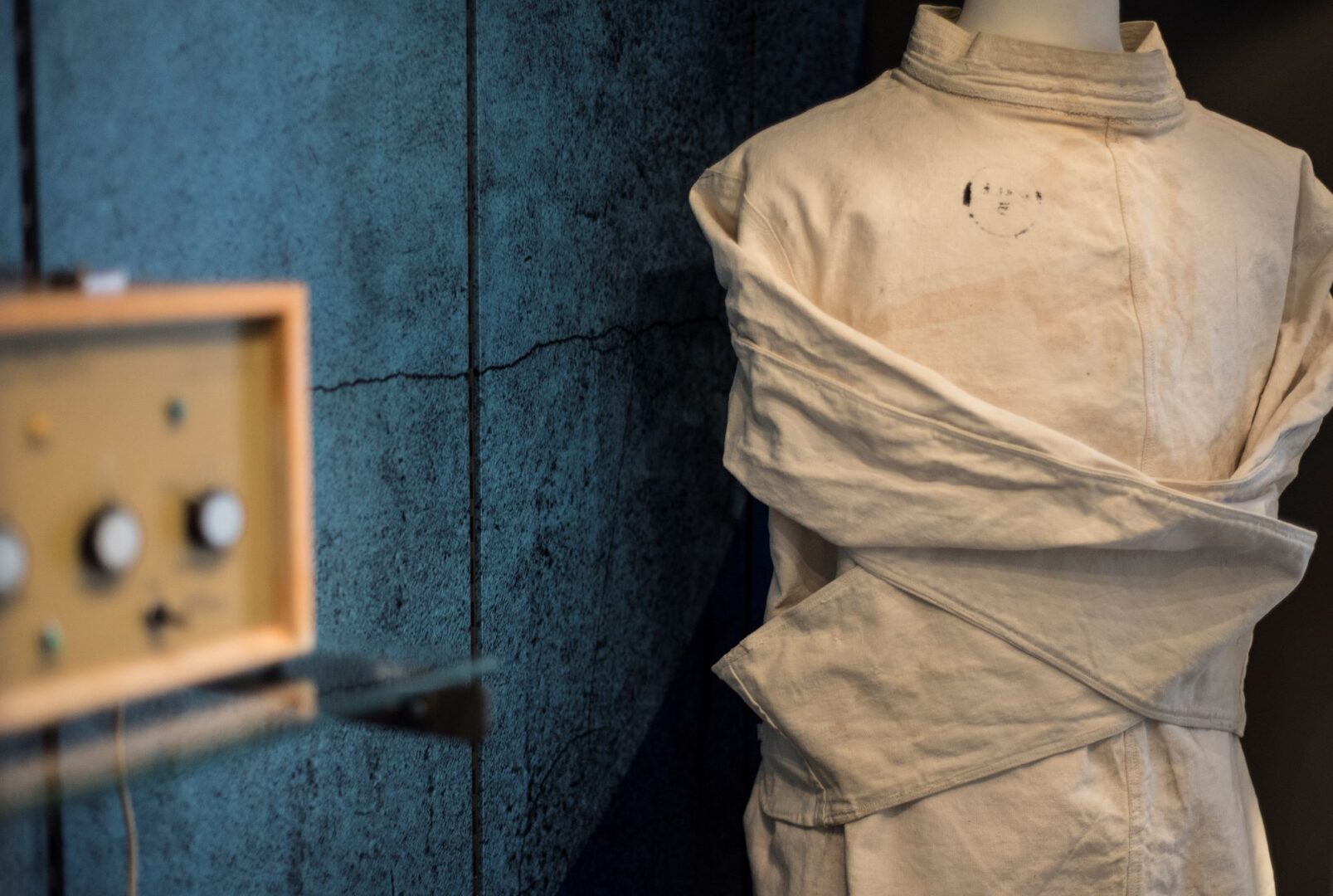 Mannequin's model wearing a cream-coloured jacket, which is tied at the back.