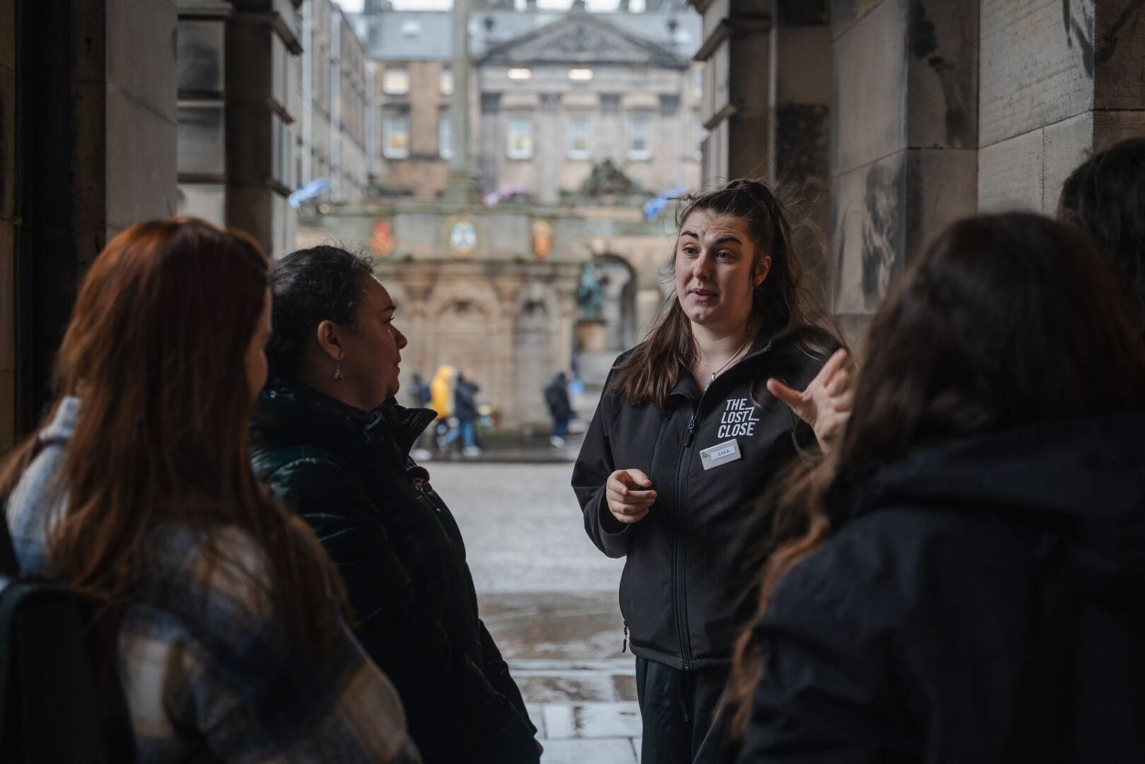 A woman talking to a group of people in an outdoor setting.