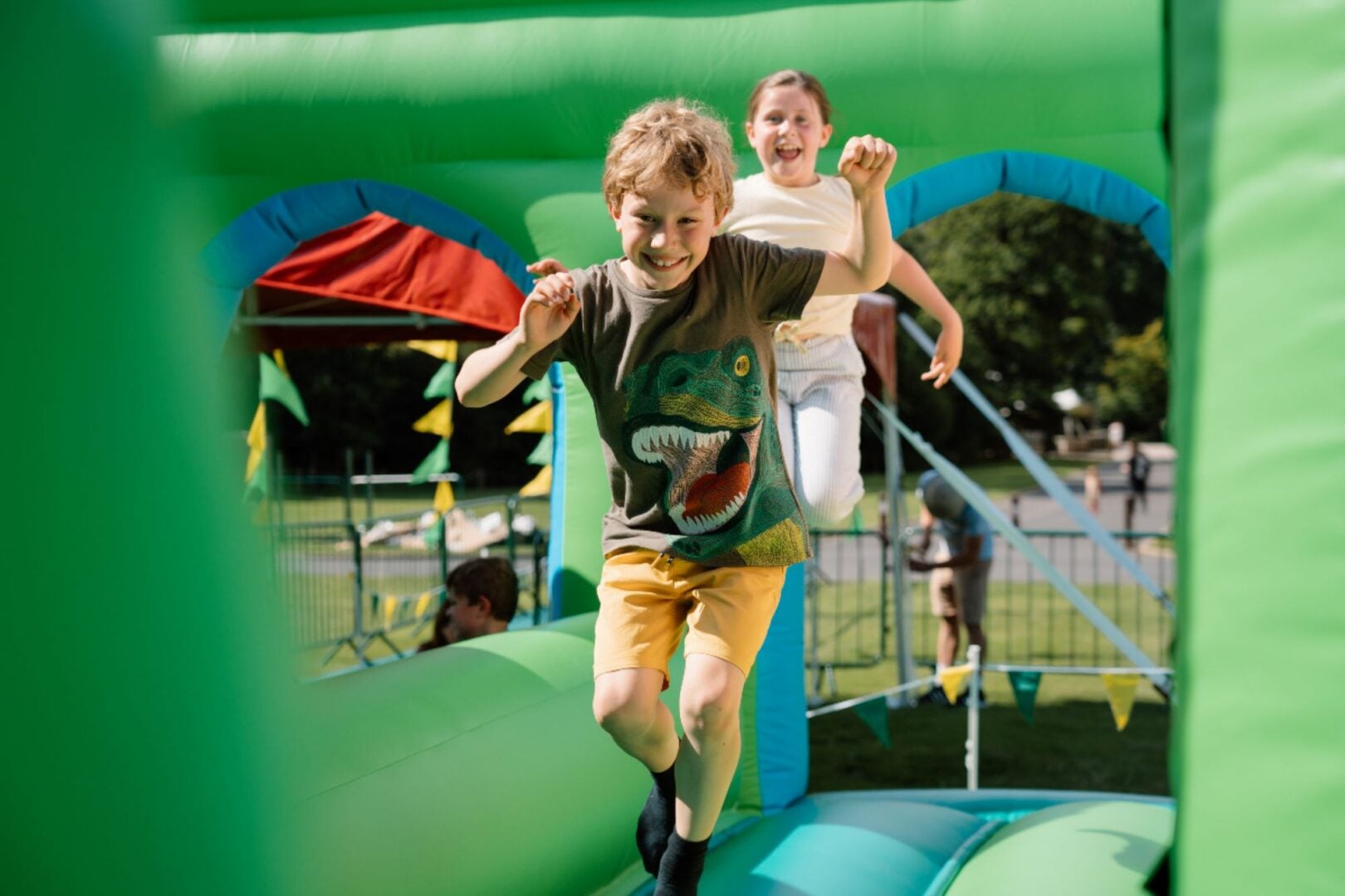 A young boy and girl running through an inflatable course.
