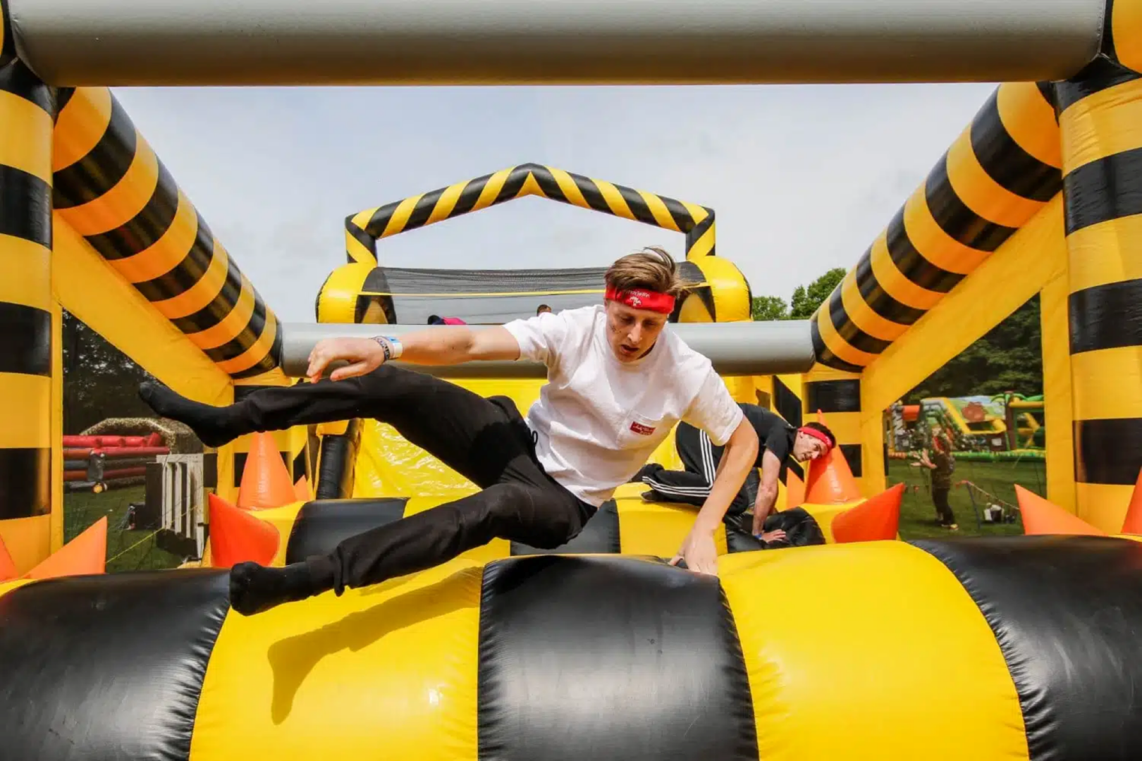 A man jumping over an inflatable tube.