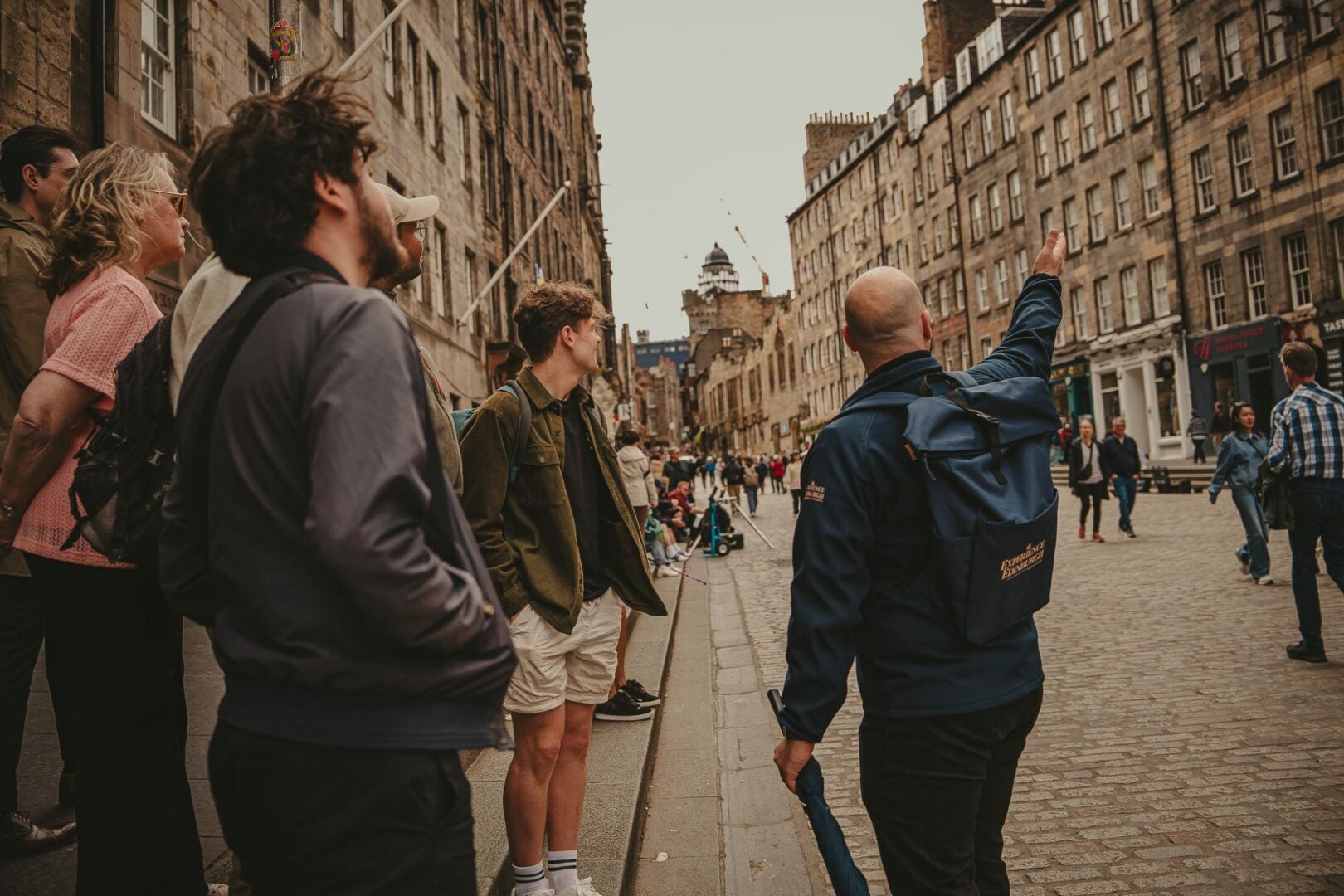 A man pointing to a group of buildings on a busy street.