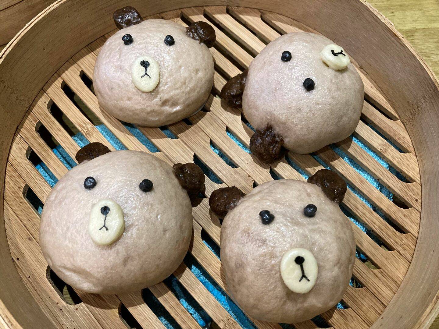 4 bao buns in the shape of a bear's face.