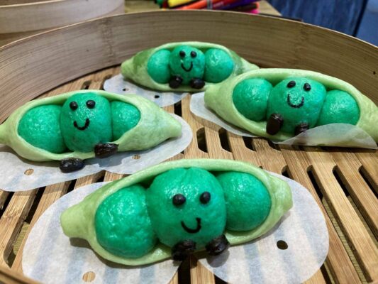4 small bao buns in the shape of peas in a pod.
