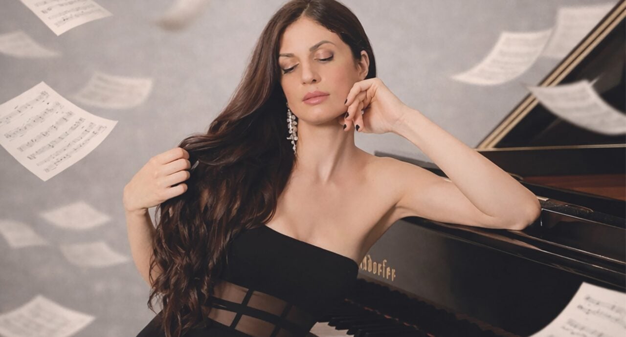 A woman in a black dress sitting at a piano, while pages of sheet music flutter in the background.