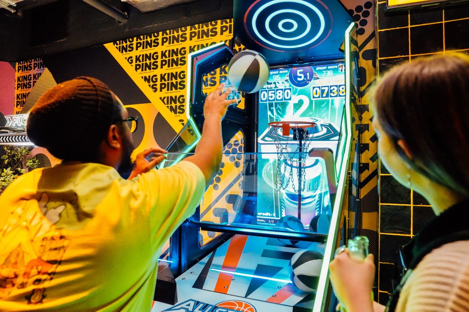People playing arcade basketball at King Pins