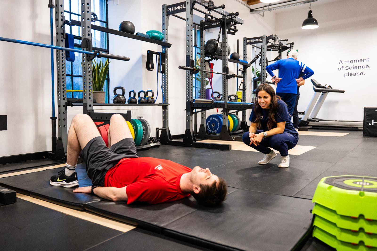 Person in gym being helped by Personal Trainer from Health by Science Personal Training