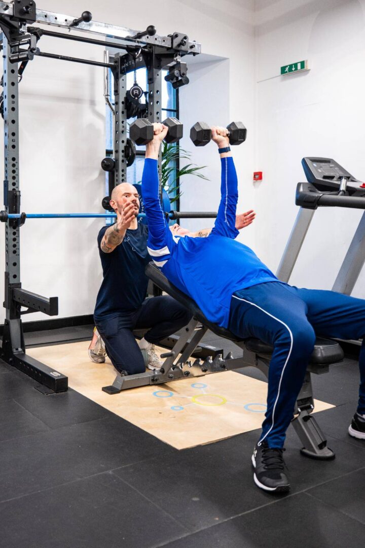 Person in gym being helped by Personal Trainer from Health by Science Personal Training
