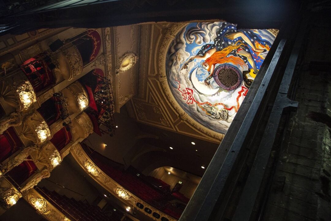 Peeking at the theatre balconies and ceiling from behind the curtain,© Anneleen Lindsay