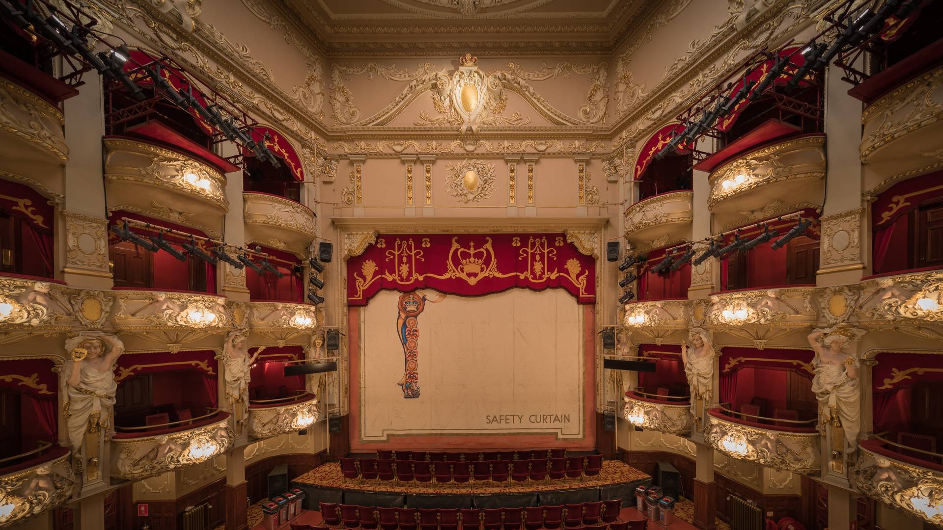 An ornate cream, gold and red theatre with curtains and balconies,© Silke Tuexen