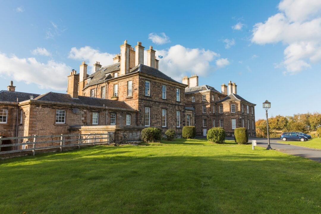 A large stately building, set in a grassy area.