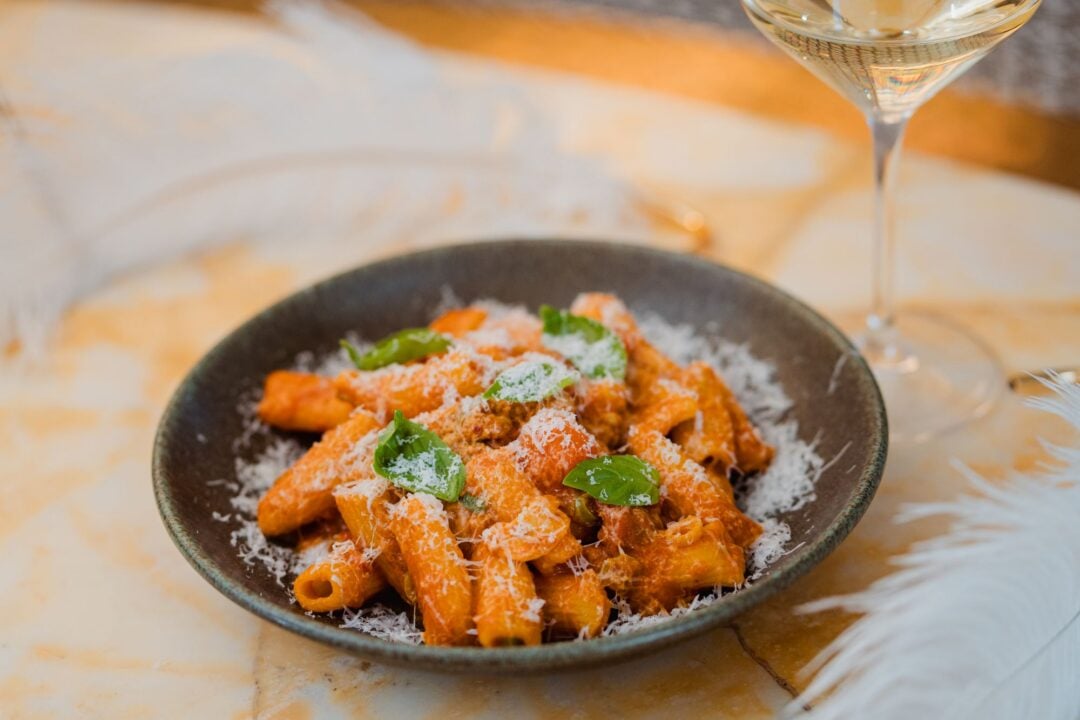 A dish of pasta tubes in a tomato sauce.