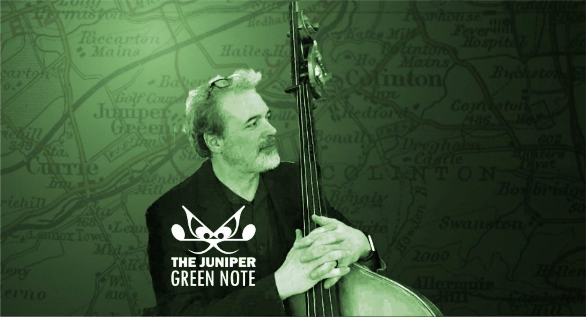 A seated man, holding a musical instrument, against a green background.
