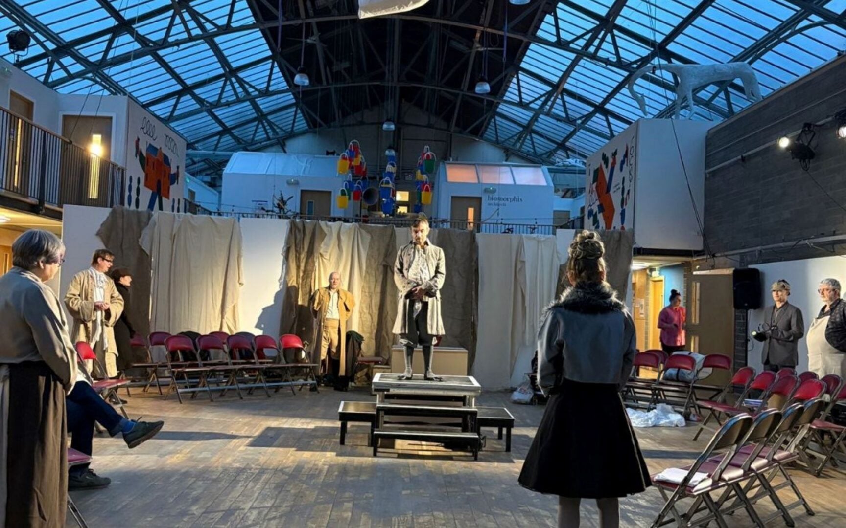 People, in various different periods of costume, performing on a stage.