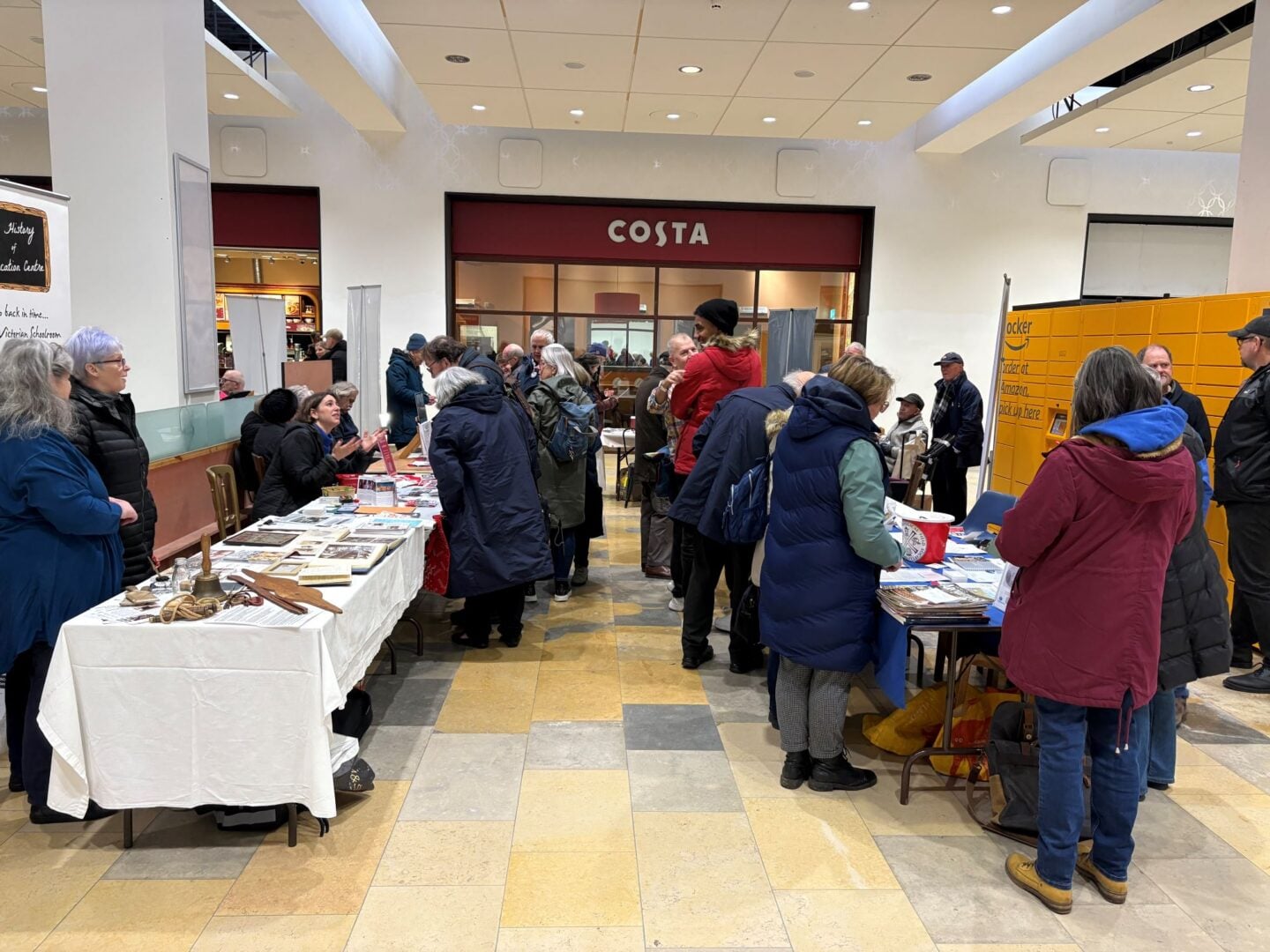 A group of people browsing information stalls.