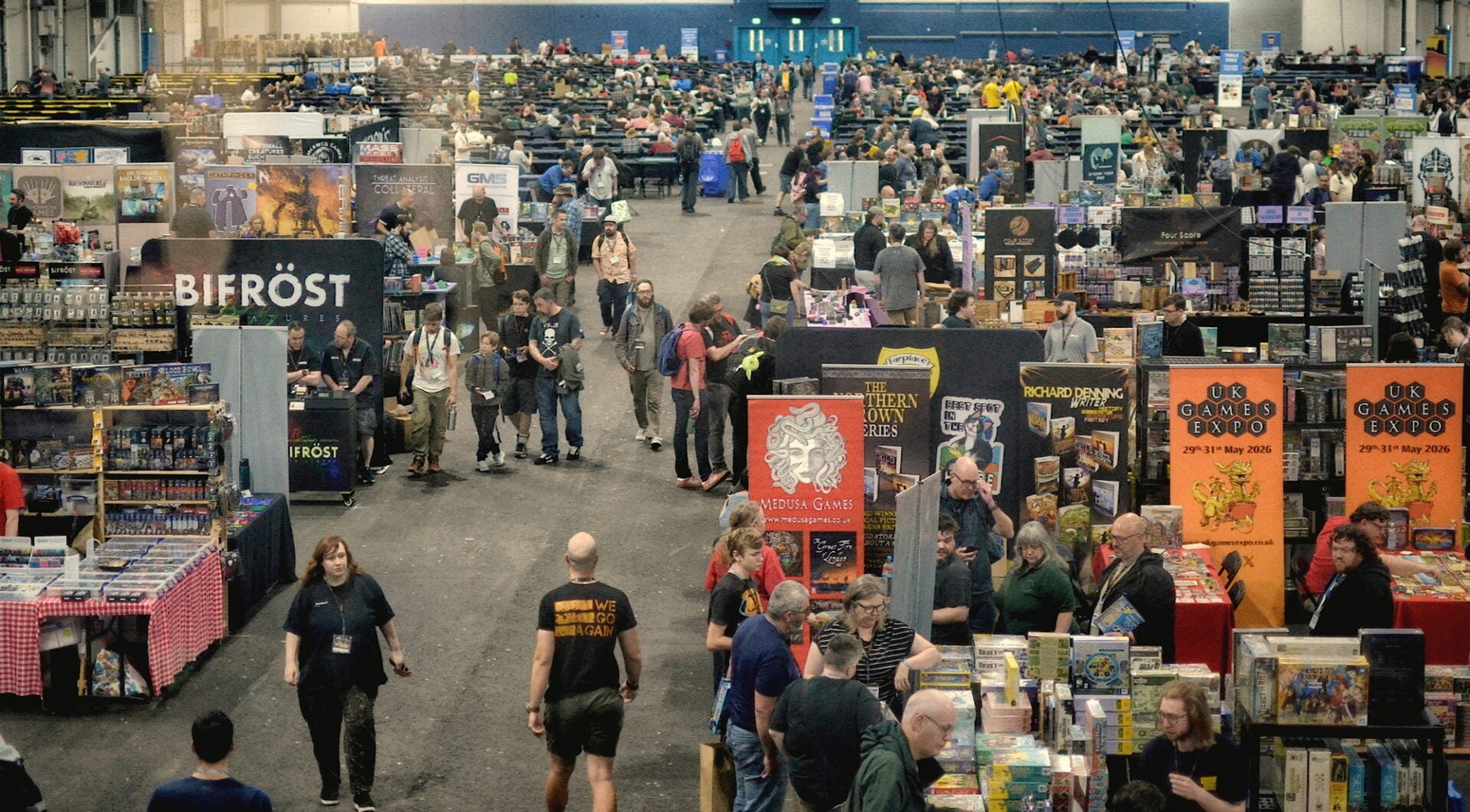 A room full of people browsing trade stalls.