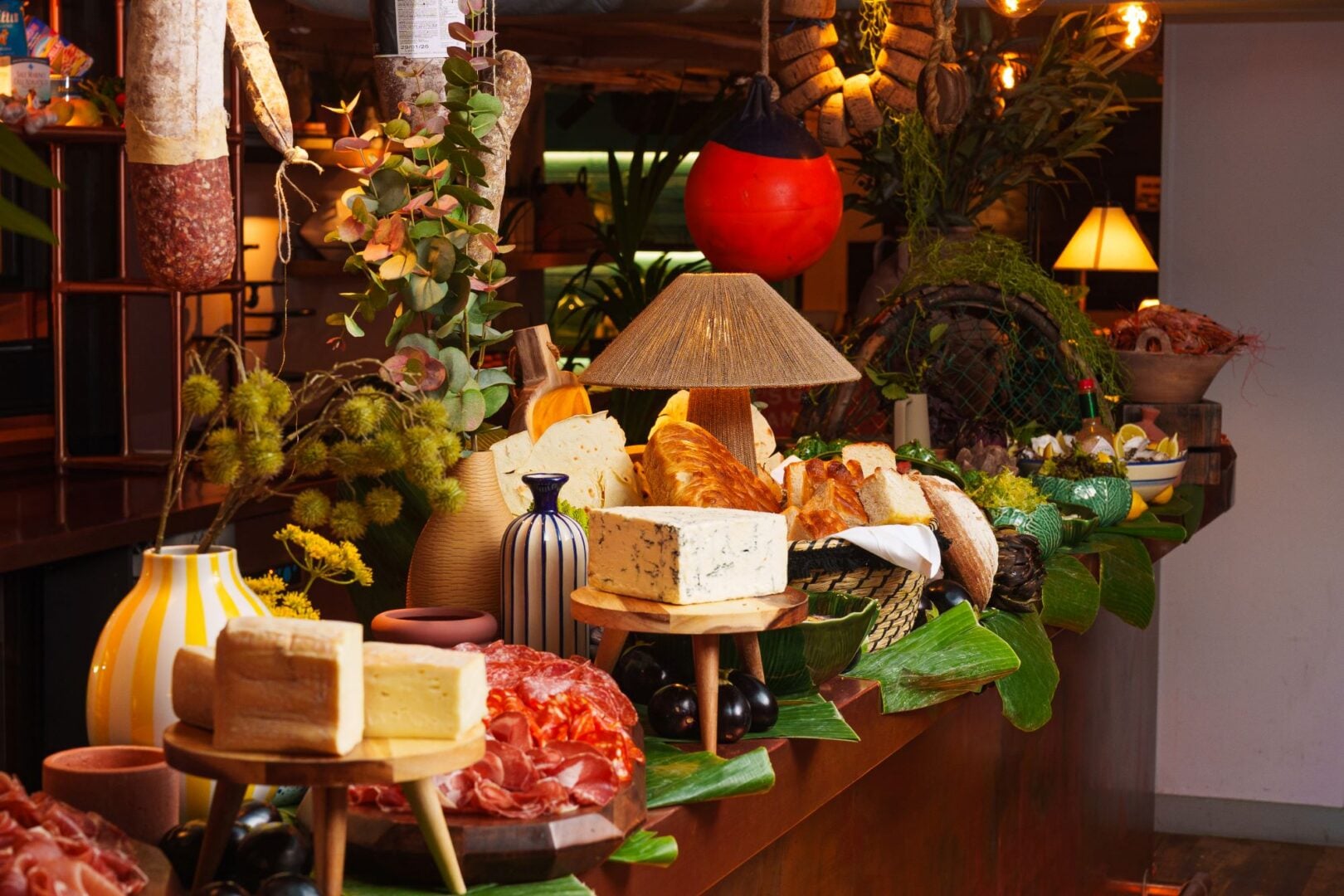Table set up with a variety of breads, cheeses, meat and cheese platters.