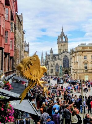 Golden eagle shop sign above a busy Edinburgh Old Town street, looking towards St Giles’ Cathedral and Parliament Square.,© Ross McDowell