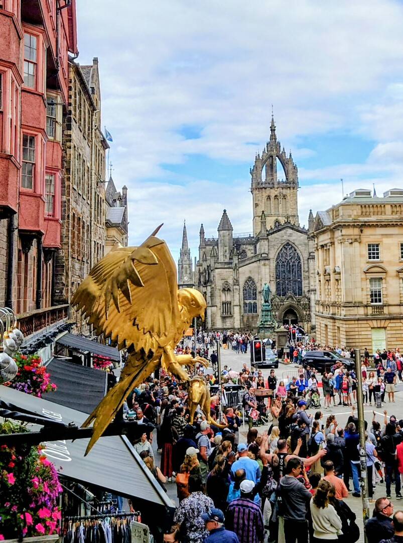 Golden eagle shop sign above a busy Edinburgh Old Town street, looking towards St Giles’ Cathedral and Parliament Square.,© Ross McDowell