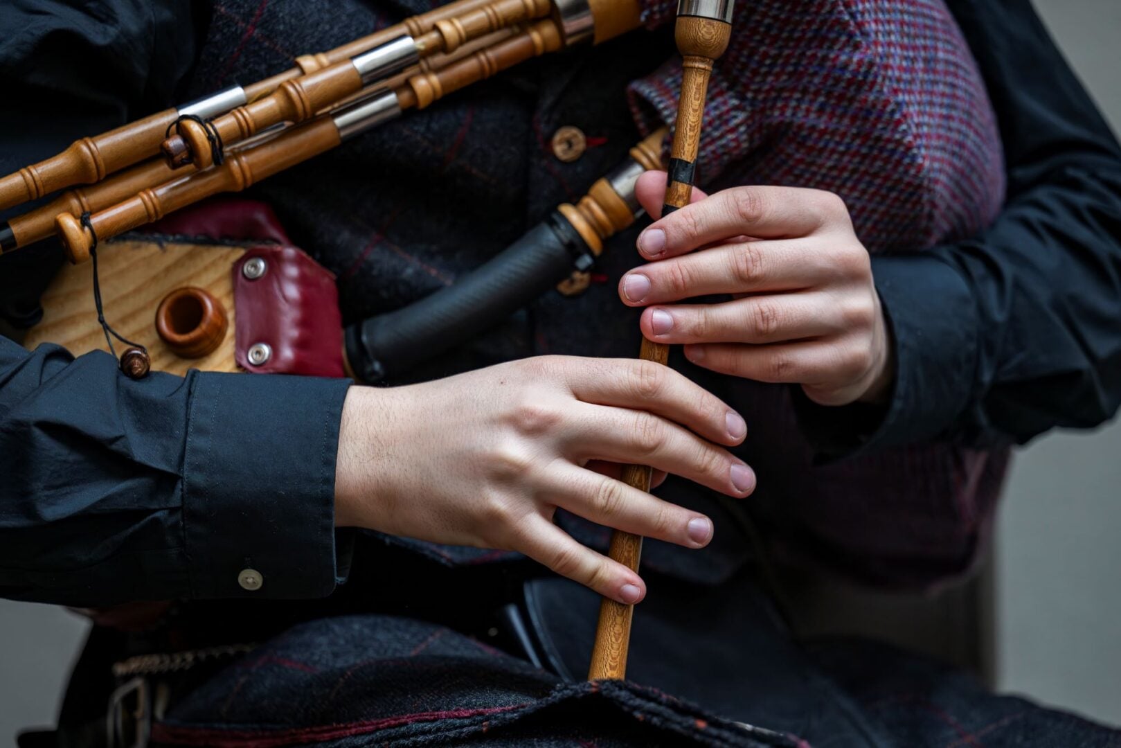 Close-up of a person's hands playing the bagpipes.