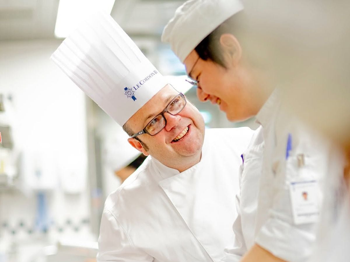 A chef smiling at a cook