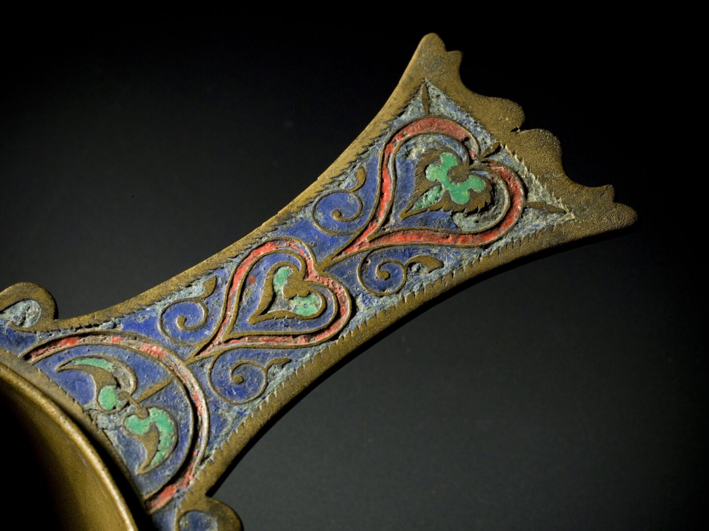 A bronze skillet, with shades of red, blue and green.